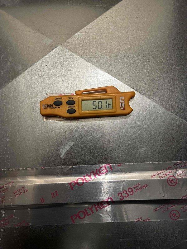 Returned for follow-up inspection one week after UV dye injection to locate refrigerant leak. Utilized ultraviolet lighting to examine refrigerant lines and connections throughout system. UV dye trace revealed leak location on copper refrigerant piping. Verified supply air temperature reading of 50.1°F at ductwork to confirm system performance during inspection.
