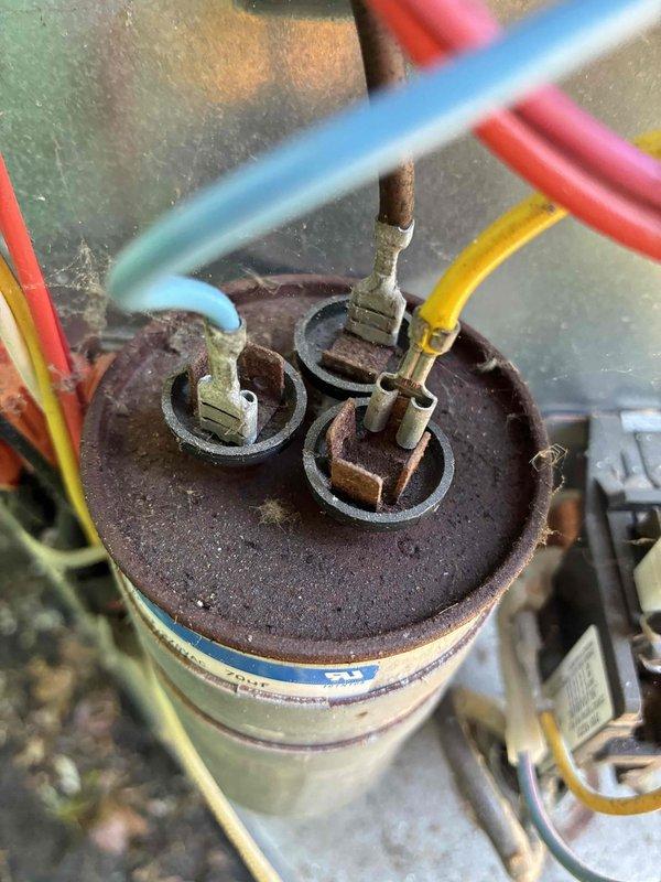 # HVAC Cooling Maintenance Summary

Completed scheduled preventive maintenance on residential cooling system. Inspection revealed a heavily corroded capacitor with extensive rust and oxidation on the terminal plate and connections. Documented the deteriorated electrical component condition with multiple wire connections (blue, red, and yellow leads) showing signs of environmental exposure and age-related degradation. Verified all electrical connections and terminal blocks within the unit. System evaluated for proper operation and safety concerns related to the corroded components.

# Detailed Service Report

Performed comprehensive cooling system maintenance as part of ongoing preventive maintenance program. Upon inspection of the outdoor condensing unit, discovered significant corrosion on the run capacitor assembly. The capacitor's metal top plate exhibited extensive rust and oxidation, with three terminal posts showing advanced deterioration. The blade-style connectors attached to t