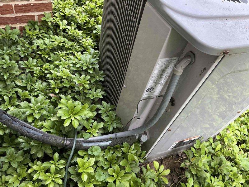 Provided comprehensive AC replacement options for existing Carrier HVAC system located in basement mechanical room with outdoor condenser unit positioned in landscaped area against building exterior. System currently features indoor air handler with ductwork connections and outdoor unit with refrigerant lines running through foundation, both units showing standard wear consistent with age. Equipment accessible for replacement with clear pathways for installation work.
