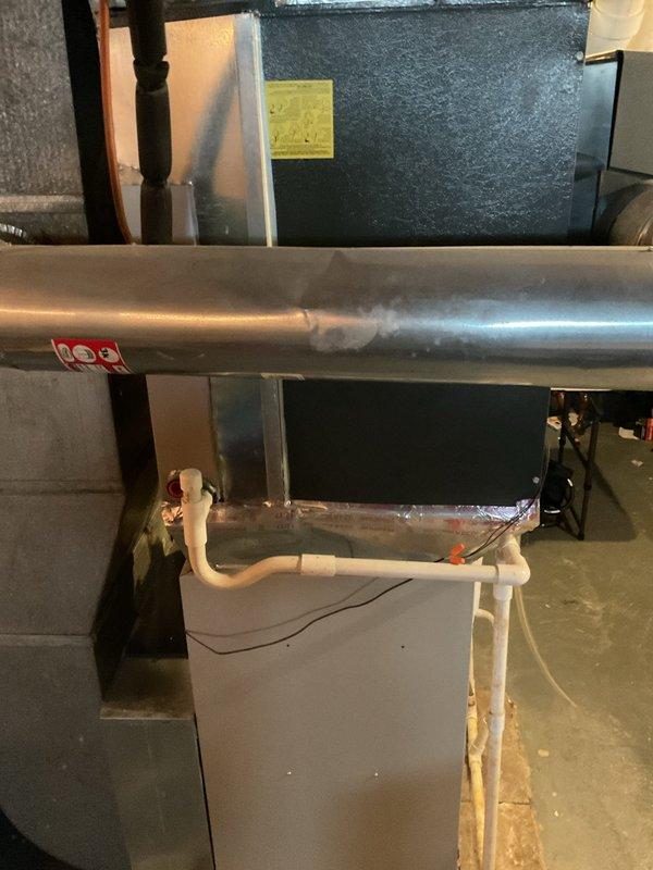 Completed comprehensive cooling season tune-up on residential HVAC system, including inspection of horizontal air handler unit with condensate pump assembly and associated drainage components. Verified system operation with digital temperature measurements showing 57.5°F supply air temperature, confirming proper cooling performance and refrigerant charge levels.