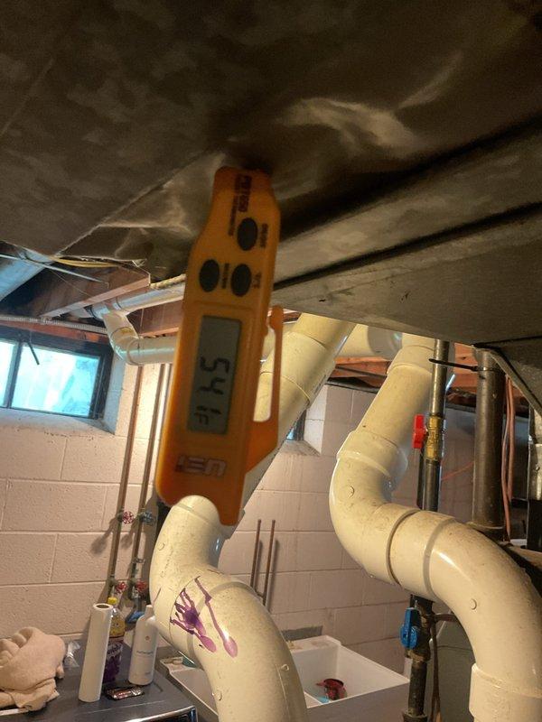 Completed comprehensive cooling season tune-up on residential HVAC system, including inspection of horizontal air handler unit with condensate pump assembly and associated drainage components. Verified system operation with digital temperature measurements showing 57.5°F supply air temperature, confirming proper cooling performance and refrigerant charge levels.