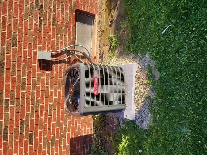 # HVAC Installation Summary

Completed full air conditioning system installation at residential property. Installed new Goodman brand outdoor condenser unit on concrete pad adjacent to brick exterior wall. Ran refrigerant lines through brick wall with proper insulation and connected to existing indoor air handler system. Verified all electrical connections, tested system operation, and confirmed proper refrigerant charge levels. Unit positioned on level pad with adequate clearance for airflow and future service access.

# Detailed Work Performed

Installed complete air conditioning system including outdoor condensing unit and associated refrigerant piping. Positioned Goodman brand condenser on existing concrete pad next to building foundation, ensuring level placement and proper drainage. Drilled penetration through brick wall for refrigerant line set routing.

Installed copper refrigerant lines with insulation wrapping from outdoor condenser through wall penetration to indoor air hand