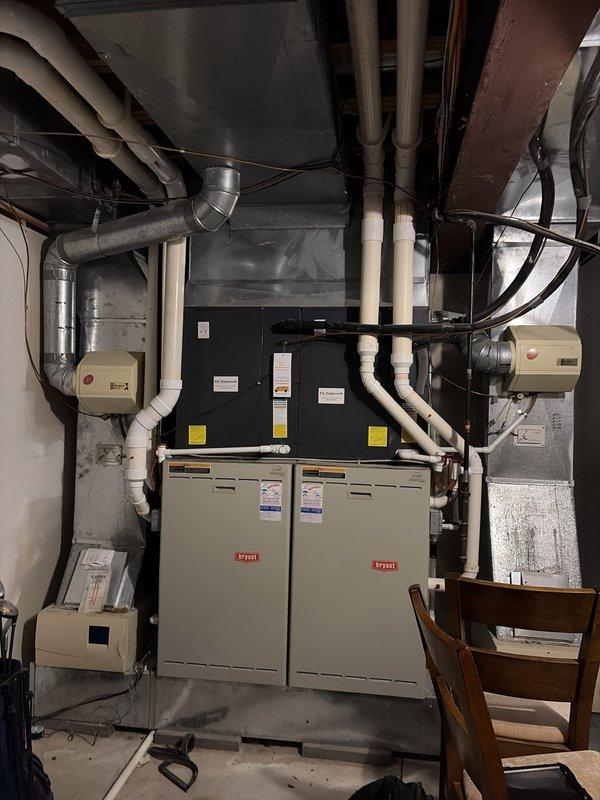 Completed preventive maintenance service on two residential cooling systems located in basement mechanical room. Performed comprehensive inspection of both Bryant HVAC units, including air handlers, condensate drain lines, and associated ductwork. Identified and addressed severely clogged air filter with excessive dust accumulation showing significant airflow restriction. Replaced dirty filter to restore proper system airflow and efficiency. Inspected PVC condensate drain lines, ductwork connections, and electrical components on both systems. Verified proper operation of cooling equipment, checked refrigerant levels, and ensured all safety controls functioning correctly. Both systems returned to optimal operating condition following maintenance procedures.