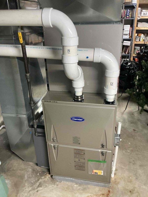 Conducted comprehensive evaluation of existing HVAC system to provide replacement versus repair options for residential forced air heating and cooling equipment. Assessed current furnace and air conditioning components, documenting equipment age, condition, and operational efficiency. Photographed existing Carrier furnace installation including ductwork connections, PVC venting system with intake and exhaust configurations, refrigerant line sets, and condensate drain lines. Evaluated basement mechanical room installation for replacement feasibility, measuring clearances and existing infrastructure compatibility. Presented detailed comparison analysis of repair costs versus complete system replacement benefits, including energy efficiency improvements and long-term reliability considerations.