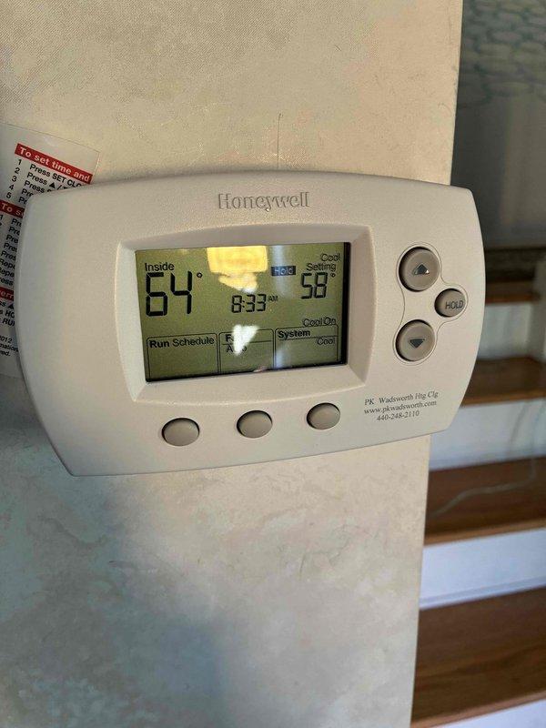 Completed scheduled preventive maintenance on residential cooling system. Verified thermostat operation with system actively running in cooling mode, confirmed proper temperature differential with supply air measuring 61.8°F at register while indoor ambient temperature read 64°F. All system components operating within normal parameters.