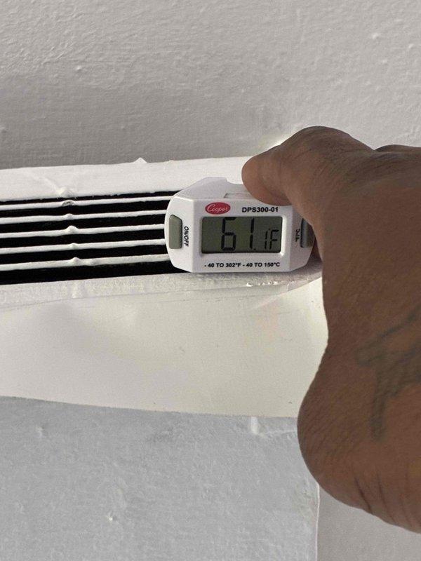 Completed scheduled preventive maintenance on residential cooling system. Verified thermostat operation with system actively running in cooling mode, confirmed proper temperature differential with supply air measuring 61.8°F at register while indoor ambient temperature read 64°F. All system components operating within normal parameters.