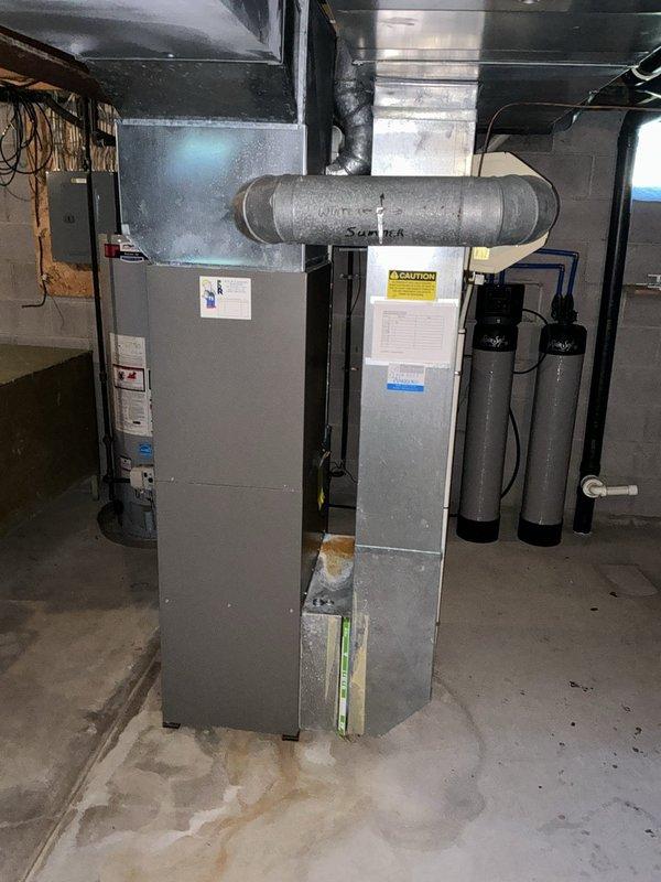 Conducted comprehensive assessment of existing HVAC system in basement mechanical room and presented full system replacement options. Evaluated current furnace/air handler unit showing signs of age and wear, including corroded gas valve components and rusted piping connections on Honeywell control assembly. Documented existing equipment configuration including ductwork layout, electrical connections, and integration with water treatment systems for complete replacement planning.