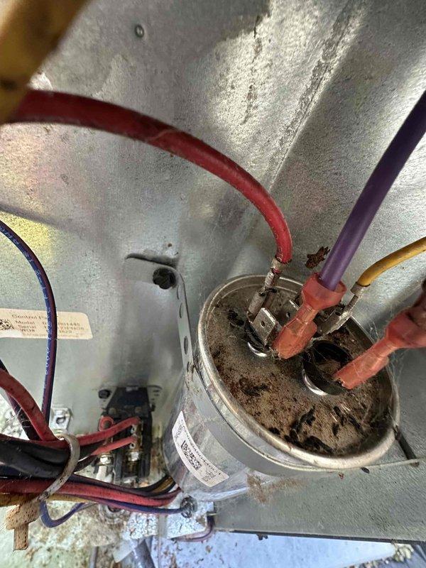 # HVAC Maintenance - Cooling System Service

Performed comprehensive preventative maintenance on residential air conditioning system. Upon arrival, conducted thorough inspection of outdoor condensing unit and indoor air handler components per customer request for routine A/C maintenance and filter cleaning.

**Outdoor Unit Inspection:**
Inspected electrical components within condensing unit cabinet, including dual-run capacitor, contactor, and associated wiring connections. Noted moderate dust and debris accumulation on capacitor terminals and housing surfaces, consistent with normal outdoor exposure. Verified all wire connections were secure with no signs of loose terminals or damaged insulation. Contactor showed normal operational wear with no pitting or damage to contact points.

**Temperature Diagnostics:**
Utilized infrared thermometer to measure supply air temperature at ductwork, recording 50.3°F at the register, indicating proper cooling performance and adequate refrigerant cha