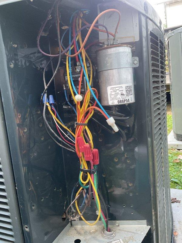 Performed routine cooling maintenance on residential Trane heat pump system. Removed access panel to inspect electrical components including capacitor, wiring connections, and control circuits. Verified all wire connections were secure with proper wire nuts in place. Examined condenser coil for cleanliness and airflow obstruction. Unit operating on concrete pad with adequate clearance from structure. All electrical components functioning within normal parameters and system ready for continued operation.