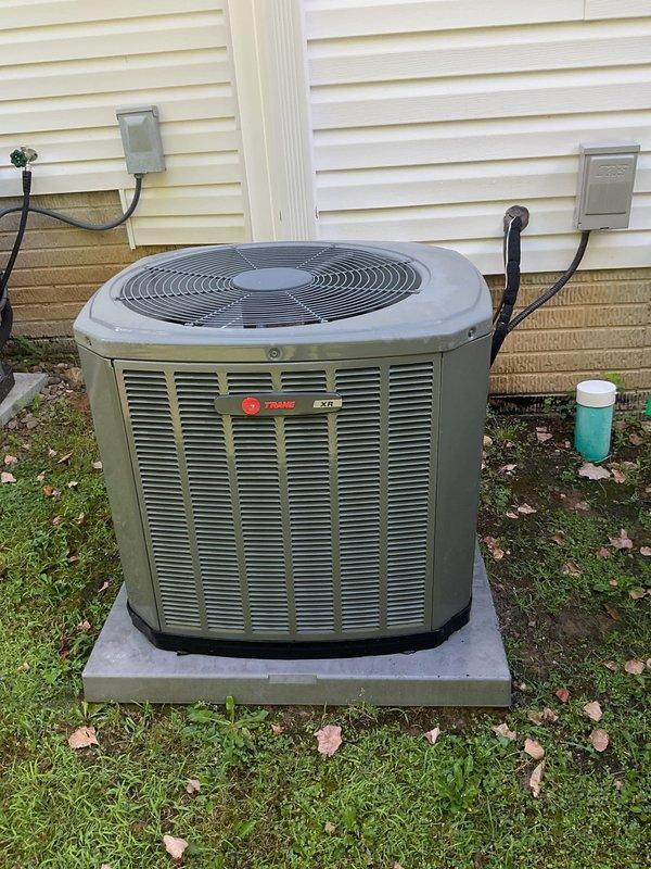 Performed routine cooling maintenance on residential Trane heat pump system. Removed access panel to inspect electrical components including capacitor, wiring connections, and control circuits. Verified all wire connections were secure with proper wire nuts in place. Examined condenser coil for cleanliness and airflow obstruction. Unit operating on concrete pad with adequate clearance from structure. All electrical components functioning within normal parameters and system ready for continued operation.