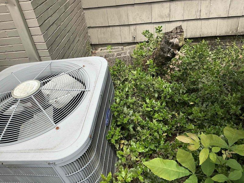 Conducted on-site evaluation of existing outdoor air conditioning condenser unit for replacement estimate. Unit displayed weathered exterior surfaces with visible discoloration and signs of prolonged outdoor exposure. Assessed surrounding conditions including overgrown vegetation encroaching on equipment, which may restrict proper airflow and reduce system efficiency. Documented current equipment specifications, installation location against exterior wall with mixed siding types, and accessibility for replacement work. Photographed existing unit positioning, clearance requirements, and electrical connections to provide comprehensive replacement options for customer consideration.