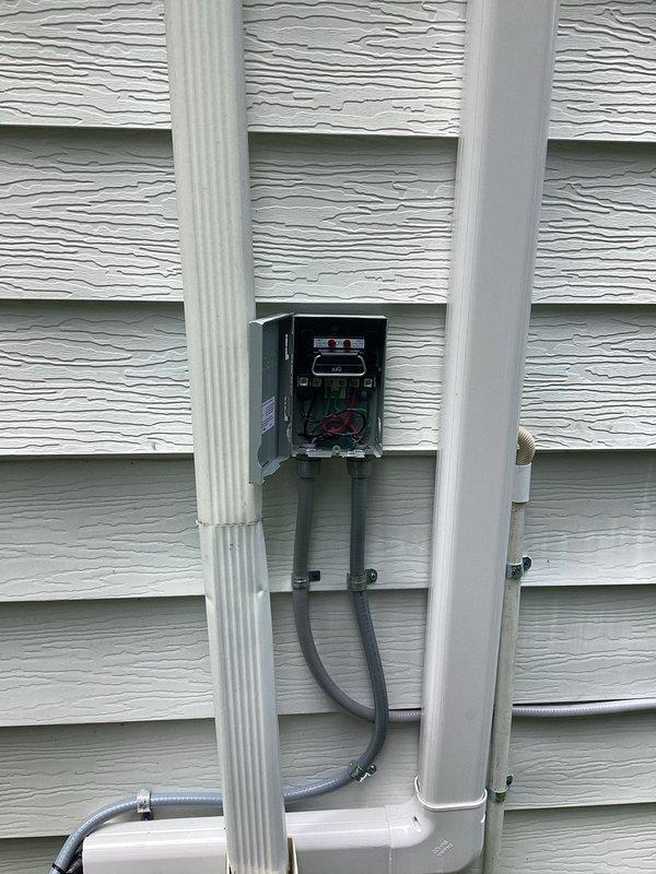 Installed new 15-amp electrical circuit with associated wiring and conduit routing. Work included modifications to the main electrical panel with proper breaker installation and labeling, exterior disconnect box integration, and professional conduit installation along the building exterior using gray electrical conduit with appropriate mounting brackets and connections to existing PVC conduit system.