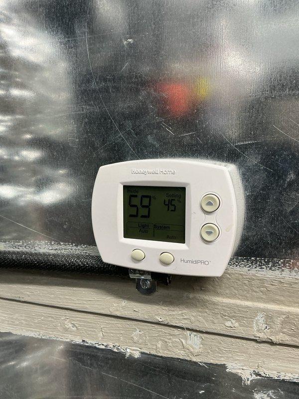 Responded to warranty service call for Daikin system originally installed by another contractor. Customer was referred to our company for warranty support after experiencing a second component failure within a few years of installation. Coordinated with original installing contractor regarding warranty part exchange and return process to distributor. Inspected humidification system components including P-trap assembly with temporary caps and HumidiPRO digital humidity controller showing operational readings. Documented equipment condition and humidifier installation for warranty records.