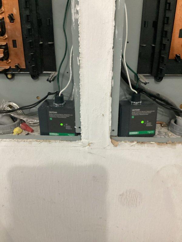 Completed electrical service and repair on HVAC equipment and power management systems. Inspected and verified proper wiring connections at equipment junction box, including red, white, yellow, pink, and black insulated conductors routed through terminal block. Serviced dual power management units with battery backup capability, confirmed operational status with green indicator lights functioning on both devices. Organized and secured electrical conduits and communication cabling. All systems tested and verified operational upon completion.