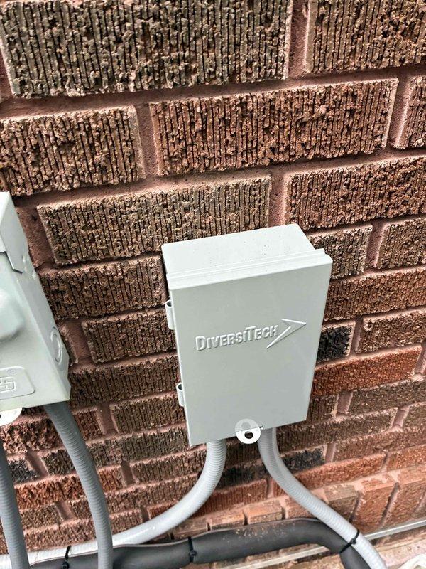 Completed installation of Unico high-velocity air conditioning system with addition of three new supply runs to expand coverage area. Installed exterior disconnect box with proper conduit routing on brick exterior wall for air handler unit. Performed system startup and commissioning, verifying refrigerant charge using digital manifold gauges with R32 refrigerant readings showing 100.7 psi low side, 262.7 psi high side, superheat at 26.3°F, and subcooling at 8.6°F within manufacturer specifications. All electrical connections secured, system tested and operational.