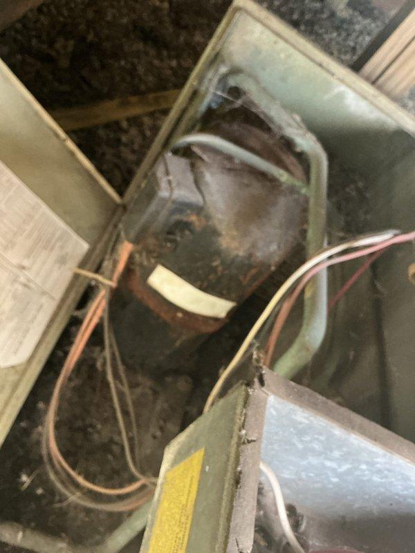 Responded to no cooling complaint on older Rheem high-efficiency outdoor unit. Upon arrival, found unit with significant age-related wear, dirt accumulation, and debris in condenser compartment. Inspected compressor motor and electrical connections, noting visible grime on cylindrical components and wiring. Assessed overall system condition and determined unit required cleaning and further diagnostic evaluation to restore cooling function.