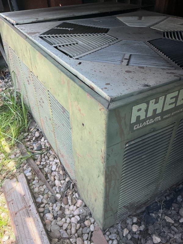 Responded to no cooling complaint on older Rheem high-efficiency outdoor unit. Upon arrival, found unit with significant age-related wear, dirt accumulation, and debris in condenser compartment. Inspected compressor motor and electrical connections, noting visible grime on cylindrical components and wiring. Assessed overall system condition and determined unit required cleaning and further diagnostic evaluation to restore cooling function.