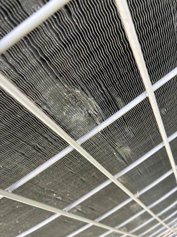 Responded to outdoor condensing unit with hail-damaged fins. Upon arrival, inspected unit and confirmed extensive fin damage affecting airflow efficiency across multiple coil sections. Performed fin combing procedure on all affected areas of condenser coils to straighten bent and compressed fins, restoring proper spacing and airflow paths. Cleaned accumulated debris from coil surfaces during repair process. Verified adequate airflow restoration through all coil sections upon completion. Unit returned to normal operating condition with improved heat transfer capability.