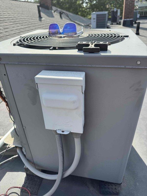 Responded to no cooling complaint on rooftop HVAC unit. Upon arrival, performed diagnostic evaluation of condensing unit and system operation. Documented equipment condition and rooftop installation with photos showing unit placement, electrical disconnect, and surrounding rooftop environment for service records.