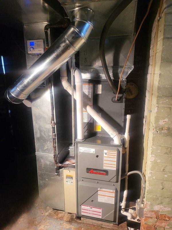 Completed full HVAC system installation including a 96% efficiency furnace, air conditioning unit, and humidifier. Installed Ameristar outdoor condensing unit on concrete pad with proper electrical connections and conduit routing to exterior junction boxes. Mounted and connected indoor furnace and air handler in basement utility area with integrated ductwork, including cylindrical supply plenum and transitions. Installed PVC drainage and venting lines, copper refrigerant lines, and digital thermostat control. System tested and verified operational with all components functioning to manufacturer specifications.