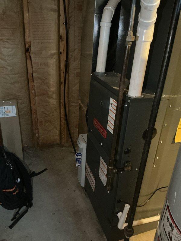 Completed scheduled preventative maintenance on residential cooling system. Performed comprehensive inspection of black HVAC air handler unit located in basement utility area, including examination of all manufacturer labels, electrical connections, and PVC condensate drain lines. Verified proper operation of unit components and checked refrigerant lines for insulation integrity. Inspected filter housing system containing multiple clean pleated air filters stored in organized metal rack, confirming adequate supply of replacement filters on-site for ongoing maintenance needs. All system components found to be operating within normal parameters with no immediate service concerns identified.