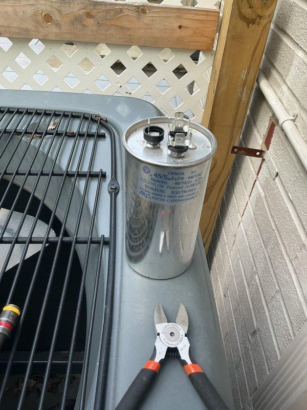 Returned to residential location to complete warranty capacitor replacement on outdoor condensing unit. Removed failed capacitor and installed new Breeze33 dual run capacitor, reconnecting all color-coded wiring leads to proper terminals. Verified secure electrical connections and proper wire routing within equipment cabinet before restoring unit to service.