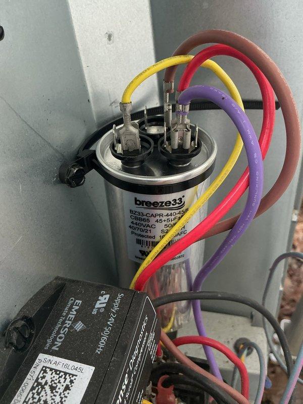 Returned to residential location to complete warranty capacitor replacement on outdoor condensing unit. Removed failed capacitor and installed new Breeze33 dual run capacitor, reconnecting all color-coded wiring leads to proper terminals. Verified secure electrical connections and proper wire routing within equipment cabinet before restoring unit to service.