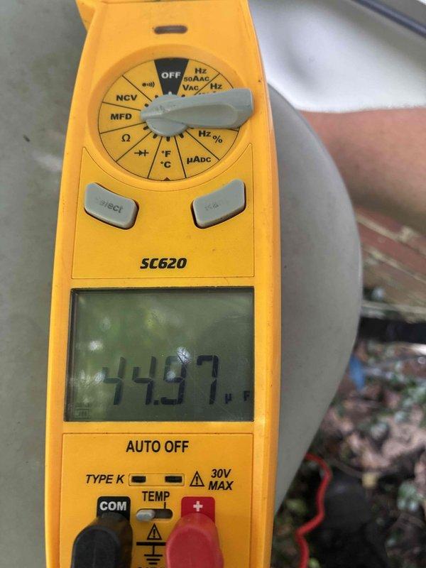 Responded to no cooling complaint and discovered severe electrical damage in outdoor unit control panel. Found extensive burn marks, charred wiring connections, and damaged wire insulation with exposed copper conductors throughout junction box. Blue wire connectors showed heat damage on yellow and brown wire connections. Heavy rust, corrosion, and organic debris accumulation indicated lack of maintenance and weather exposure. Verified electrical readings using digital multimeter. Documented all damaged components and hazardous conditions for repair recommendations.