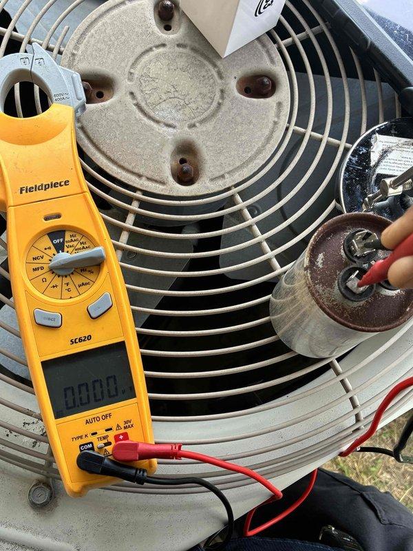 Responded to no cooling complaint on residential air conditioning system. Upon inspection, identified failed dual run capacitor on outdoor condenser unit showing significant corrosion and deterioration. Tested capacitor with digital multimeter, confirming reading of 49.6 MFD, well below manufacturer specifications. Replaced defective capacitor with new component, verified proper electrical connections, and tested system operation to ensure restoration of cooling function.
