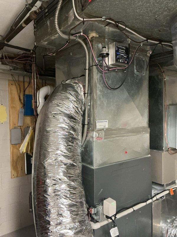 Responded to callback for recurring E2 error code on whole-home dehumidifier unit that was previously serviced. Inspected dehumidifier control board, electrical connections, and drainage system to diagnose the service required error message. Documented system configuration with air handler and dehumidifier installation, verified proper wiring connections and flexible ductwork connections to both units.