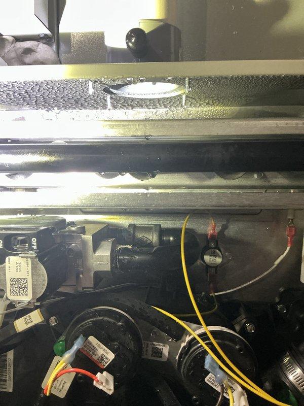 Responded to customer report of air conditioning system not performing well with possible control board issue and abnormal display readings. Upon arrival, inspected basement-mounted HVAC system and observed significant condensation on evaporator coil assembly and surrounding components, indicating active cooling cycle. Evaluated control board operation, verified system diagnostics on display panel, and documented equipment condition including water heater and furnace configuration. Photographed internal components showing moisture accumulation on metallic ductwork, yellow foam insulation, and blower assembly with visible electrical connections and manufacturer identification labels for further assessment and recommended follow-up service.