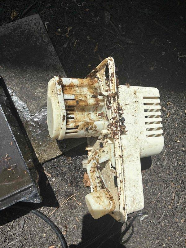 Responded to no cooling complaint and diagnosed failed blower motor assembly with severe corrosion damage to housing and internal components. Removed deteriorated blower unit showing extensive rust on metal framework and cracked plastic housing, replaced with new assembly, and restored proper airflow to system.