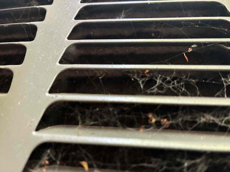 Responded to no cooling complaint at residential property. Upon arrival, performed visual inspection of HVAC system and identified severely restricted airflow due to excessive debris accumulation. Found condenser coils heavily clogged with dirt, dust, and organic material buildup between fins, significantly reducing heat transfer efficiency. Return air grilles obstructed with substantial cobweb accumulation and debris, restricting proper air circulation throughout the system. Thoroughly cleaned condenser coil fins to restore optimal heat exchange capacity. Removed all cobwebs and debris from return air vents and grilles. Cleared blockages from airflow pathways to restore proper system ventilation. Verified system operation after cleaning, confirming restored cooling functionality and adequate airflow. Unit now operating within normal parameters.