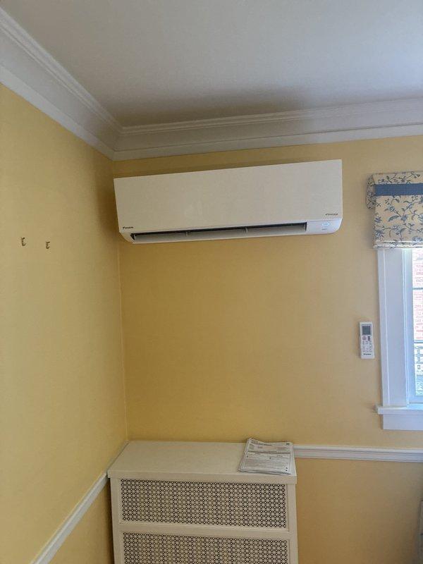 Completed installation of ductless mini-split heat pump system with indoor wall-mounted air handler unit installed in living space and line set routed through basement utility area to outdoor condenser location. Electrical connection deferred to scheduled follow-up appointment per customer coordination requirements.