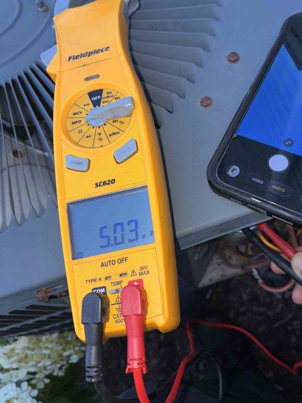 Completed preventive maintenance service on Rheem cooling system. Performed electrical diagnostics using digital multimeter, measuring amperage draw at 19.52A and capacitance reading at 5.03 MFD on system components. Inspected condenser unit, verified proper electrical connections, and tested all operating parameters. System operating within normal specifications upon completion of scheduled maintenance visit.