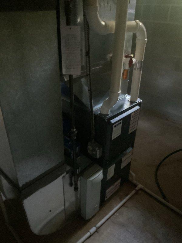 Performed comprehensive cooling system maintenance on residential HVAC unit. Conducted temperature differential measurements across the air handler using calibrated digital instrumentation, recording supply air temperature of 51.24°F to verify proper cooling performance. Inspected complete system including vertically-mounted air handler, ductwork connections, and stacked heating components in basement installation. Verified all PVC condensate drain lines, refrigerant piping, and electrical connections were secure and functioning properly with no visible leaks or damage noted.
