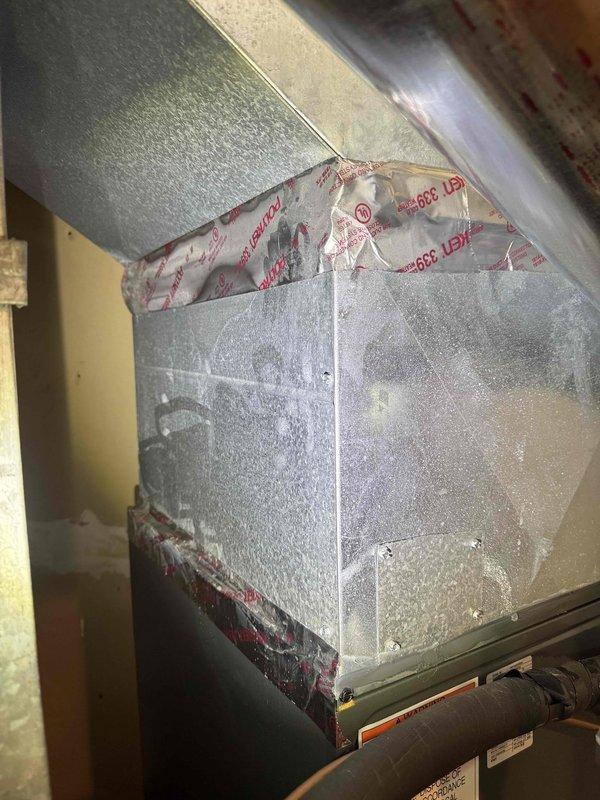Responded to recurring water leak issue on HVAC system that was previously reinstalled 1.5 months prior. Upon arrival, observed heavy condensation and frost accumulation on supply ductwork indicating ongoing moisture problem that has caused property damage. Inspected condensate drain system and confirmed water sensor safety float switch is malfunctioning and not shutting down unit when water is present. Documented extensive condensation on metal ductwork and inadequate insulation at duct seams, as well as condensate management system requiring repair to prevent further water damage.