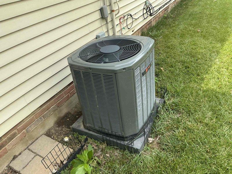 Conducted comprehensive HVAC system evaluation for equipment replacement estimate. Assessed existing outdoor air conditioning condenser unit and indoor climate control components, documenting current system configuration including exterior condensing unit positioned on concrete pad with protective platform, associated refrigerant line routing, and electrical connections. Reviewed interior thermostat functionality and compatibility requirements for potential system upgrade, photographed equipment specifications and installation details to provide accurate replacement options for complete HVAC system modernization.