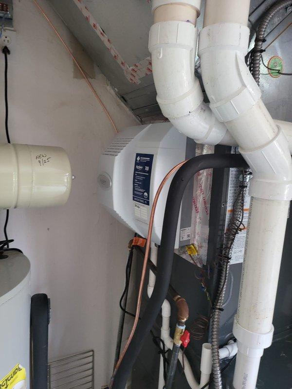 Upgraded existing humidifier system by removing the previous 600 model and installing an Aprilaire Model 700 whole-home humidifier mounted to the supply ductwork. Installed safety switch in the utility area between the water heater and furnace to provide proper overflow protection. Connected humidifier to water supply line using copper tubing and integrated unit with existing HVAC ductwork. Routed electrical wiring to humidifier control panel and verified proper operation of all components. All plumbing connections secured and tested for leaks, with PVC drainage properly configured to safety switch location.