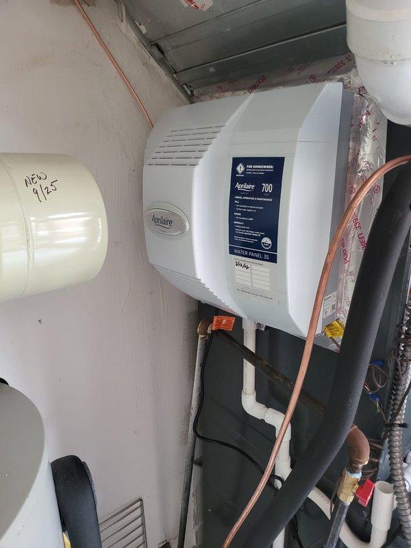 Upgraded existing humidifier system by removing the previous 600 model and installing an Aprilaire Model 700 whole-home humidifier mounted to the supply ductwork. Installed safety switch in the utility area between the water heater and furnace to provide proper overflow protection. Connected humidifier to water supply line using copper tubing and integrated unit with existing HVAC ductwork. Routed electrical wiring to humidifier control panel and verified proper operation of all components. All plumbing connections secured and tested for leaks, with PVC drainage properly configured to safety switch location.