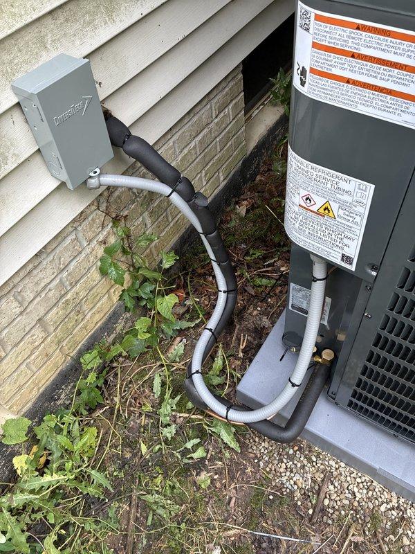 Completed installation of new residential air conditioning system. Installed outdoor condensing unit on existing concrete pad adjacent to building exterior with proper clearances maintained. Ran electrical disconnect and conduit from building-mounted disconnect box to unit per code requirements. Verified all electrical connections, tested system operation, and confirmed proper unit function upon startup.