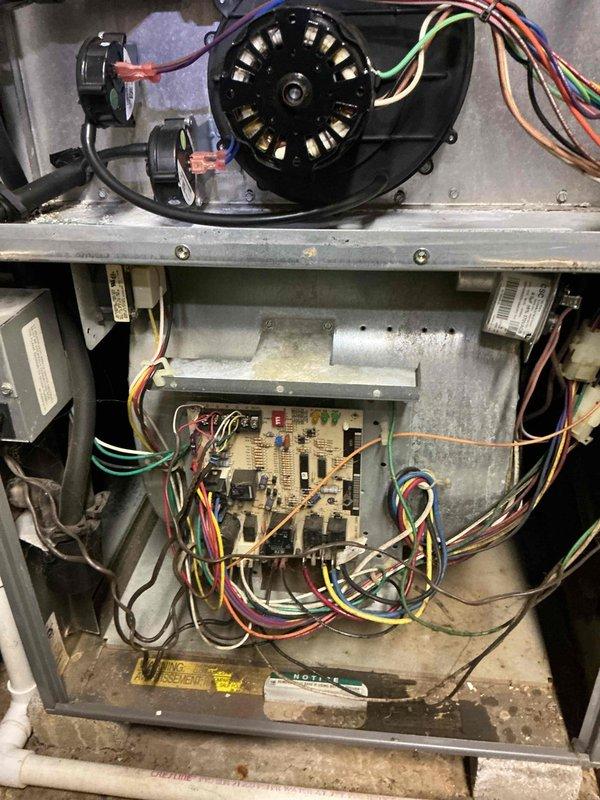Responded to no cooling complaint with thermostat set to 72°F but reading 78°F with minimal airflow from supply vents. Inspected HVAC system interior components including blower motor assembly, control board, transformer, and electrical connections. Documented internal system condition showing operational wear and dust accumulation on blower assembly and control components for service records.