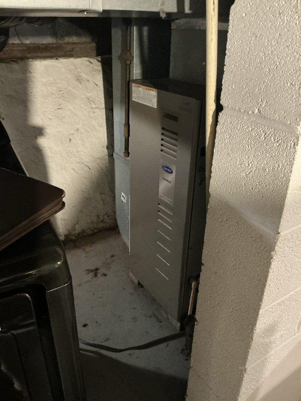 Conducted on-site assessment for furnace replacement in residential property. Evaluated existing Carrier heating unit located in basement utility area and documented current thermostat wiring configuration showing standard HVAC terminal connections (RC, W, Y, G, O, B terminals with corresponding colored wires). Presented homeowner with multiple furnace replacement options for complete system upgrade. Property currently has heating only with no air conditioning system installed.