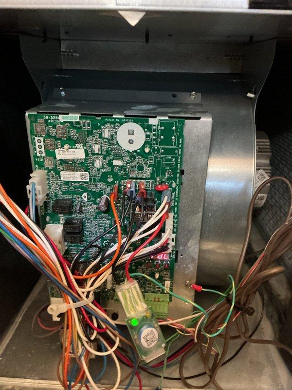 Replaced defective control board under warranty on HVAC system. Removed failed circuit board from control panel enclosure and installed new green PCB with all electronic components properly seated. Reconnected all multi-colored wiring harnesses to appropriate terminals on new board, including power supply connections, blower motor leads, and sensor wires. Verified all wire connections were secure at both board connectors and wire terminals. Tested system operation to confirm proper functionality of new control board and all connected components.