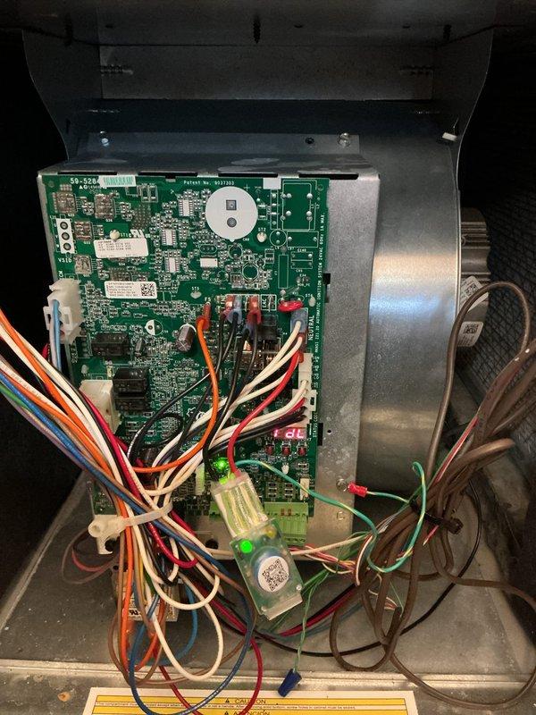 Replaced defective control board under warranty on HVAC system. Removed failed circuit board from control panel enclosure and installed new green PCB with all electronic components properly seated. Reconnected all multi-colored wiring harnesses to appropriate terminals on new board, including power supply connections, blower motor leads, and sensor wires. Verified all wire connections were secure at both board connectors and wire terminals. Tested system operation to confirm proper functionality of new control board and all connected components.