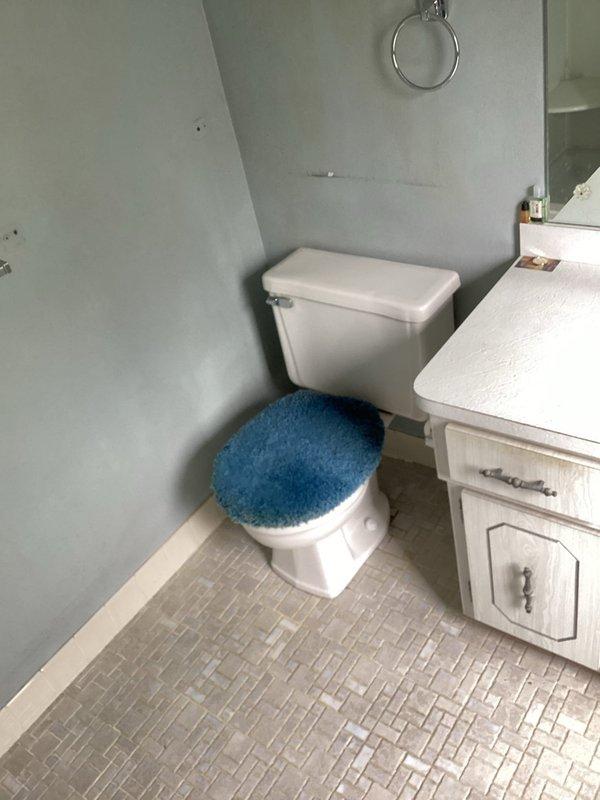 Completed toilet installation in compact upper-floor bathroom with angled ceiling configuration. Installed standard two-piece white porcelain toilet with proper mounting, sealing, and water supply connection. Verified proper flush operation and checked for leaks at all connection points.