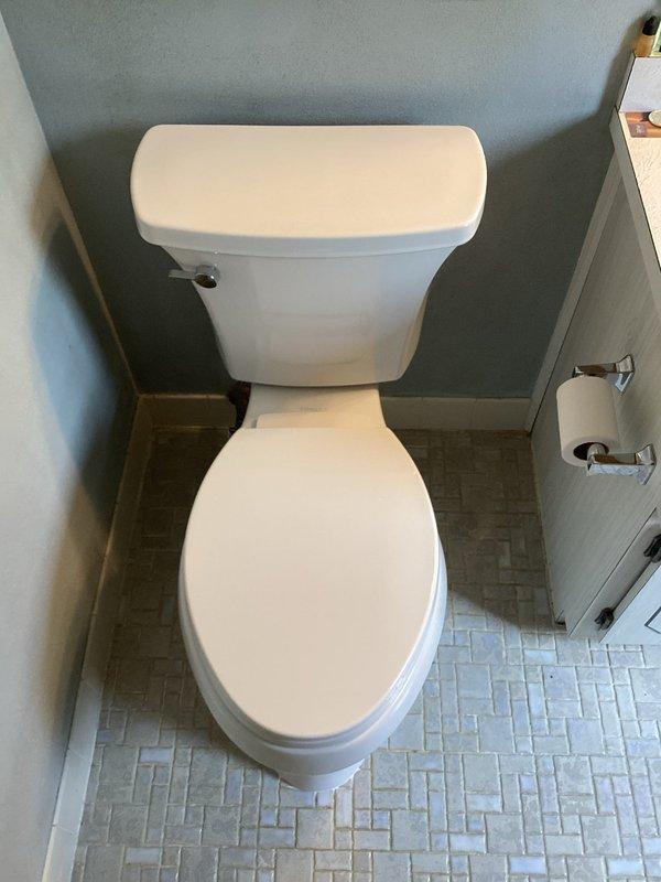 Completed toilet installation in compact upper-floor bathroom with angled ceiling configuration. Installed standard two-piece white porcelain toilet with proper mounting, sealing, and water supply connection. Verified proper flush operation and checked for leaks at all connection points.