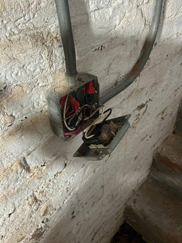Conducted comprehensive electrical inspection of residential crawl space and mechanical room installations. Verified proper routing and securing of yellow electrical conduit with appropriate mounting clips to floor joists, ensuring compliance with code requirements for protection and support spacing. Inspected junction box installation in mechanical area with gray conduit entry points, confirmed wire connections utilizing red and black terminal blocks, and verified proper box mounting to wall surface. Documented all electrical components, conduit pathways, and wire management systems through detailed photography for record-keeping purposes. All observed installations met current electrical code standards for residential applications.