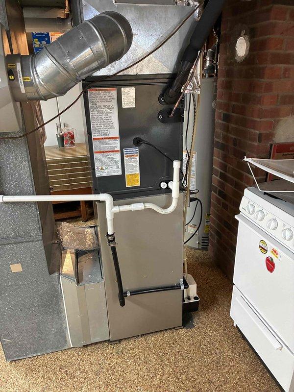 Completed full HVAC air conditioning system installation including outdoor condenser unit mounted on concrete pad with proper refrigerant line routing through exterior wall. Connected new A/C system to existing furnace infrastructure with appropriate ductwork integration and electrical connections. System tested and verified operational with proper airflow and cooling capacity.