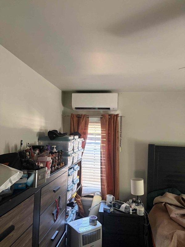 Completed installation of multi-zone ductless mini-split system with five indoor air handler units throughout the residence. Installation coordinated with electrical contractor for proper power supply and circuit requirements. Mounted wall-mounted indoor unit in bedroom above window, installed refrigerant line sets, established proper condensate drainage, and commissioned system with successful operational testing verified by control panel indicators showing power, lock, and WiFi connectivity status.